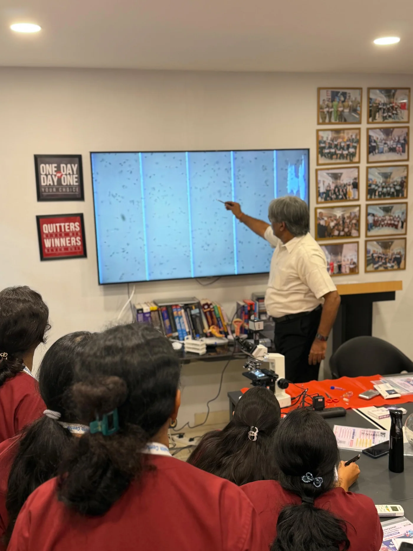 Gynaecologists observing a projected microscope field during male infertility training in Delhi